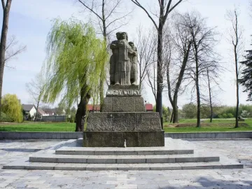The War Never Again monument in Żabikowo shows three embraced figures on a stepped pedestal with the inscription \