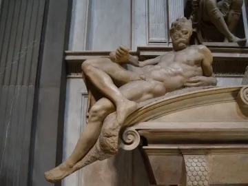 Michelangelo’s Evening, a reclining marble male figure with a bearded face in the Medici Chapel.