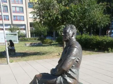 Willy Brandt memorial bronze statue seated on a wooden bench outdoors