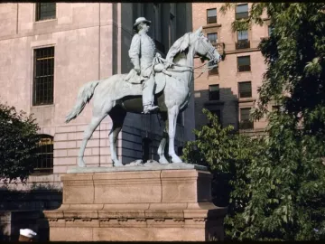 Joseph Hooker statue depicting a bronze equestrian figure on a multi-tiered stone pedestal, surrounded by trees and city buildings.