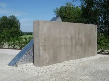 Hailfingen-Tailfingen Memorial with a tall concrete wall and angular metal structure beside it.