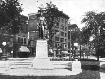 Stevens T. Mason Monument with a bronze figure on a tall stone pedestal in an urban park setting.