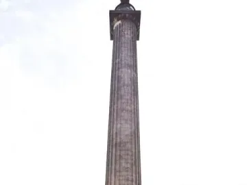 The Melville Monument rising above a green park with people walking along paved paths.