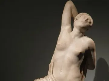 The Niobid from the Gardens of Sallust, a pale marble sculpture of a kneeling female figure with one arm raised behind her head.