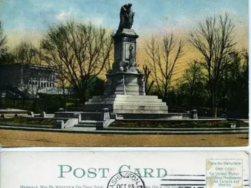 Peace Monument with a tall stone pedestal, draped figure on top, and smaller sculpted figures below, surrounded by a circular planter and steps.
