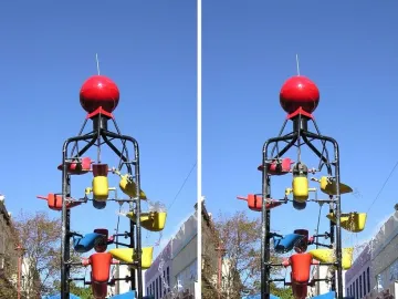 The Bucket Fountain sculpture with colorful tipping buckets spraying water against a blue sky.