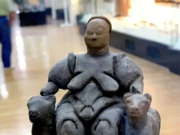 Seated Woman of Çatalhöyük figurine with rounded forms and animal-headed armrests.