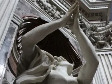 Bernini\'s Daniel and the Lion marble sculpture with raised arms in an ornate niche