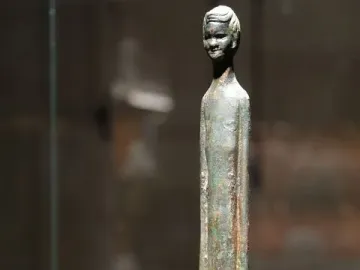 Detail of Ombra della sera, showing a slender bronze figure with an elongated body and serene carved head.