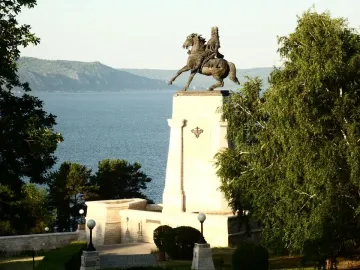 Tatishchev Monument showing a rider on a rearing horse atop a tall stone pedestal by the water.