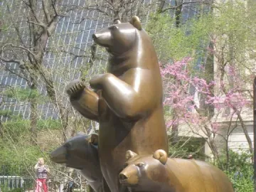 Group of Bears sculpture in Central Park, showing a bronze bear standing upright with two bears below it.