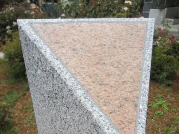 A grey granite pillar with a pink-speckled triangular top at Pink Triangle Park.
