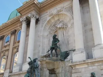 Fountain of King Matthias with bronze figures in front of a palace facade in Budapest