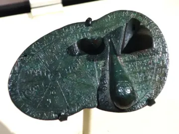Bronze Liver of Piacenza with engraved lines, inscriptions, and uneven raised sections.