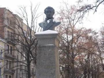 Bust of Pushkin on a tall stone pedestal in a snowy outdoor setting.