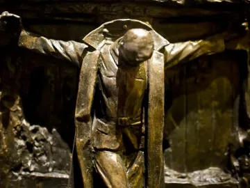 Canada\'s Golgotha bronze sculpture showing a bowed soldier with outstretched arms against a textured wall