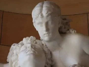 Mercury and Psyche carved in white stone, shown in close-up with one figure looking upward and the other leaning over his shoulder.