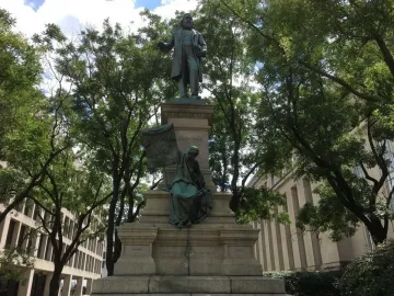 Albert Pike Memorial with a standing bronze figure on a tall pedestal and a seated draped figure below it