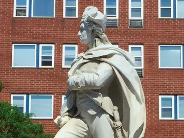 George Washington marble statue in military attire standing on a pedestal