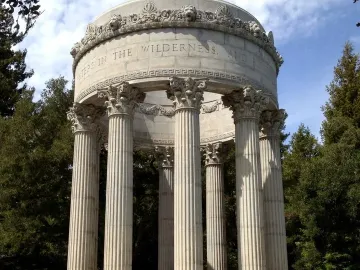 Pulgas Water Temple stone monument with fluted columns and a domed roof surrounded by trees.