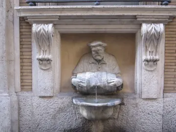 The Porter fountain statue of a bearded man in a cap pouring water from a barrel into a basin.