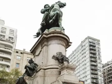 Monument to Giuseppe Garibaldi with a bronze equestrian statue atop a tall stone base and relief panels.