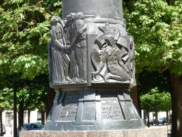 Lower section of the Mickiewicz monument showing bronze relief panels and inscriptions on the socle.