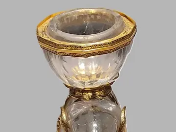 Rock crystal elephant with gold-colored tusks, ears, and feet carrying a faceted salt vessel.