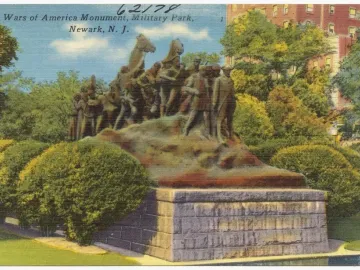 Wars of America monument showing multiple figures and mounted riders atop a stone base in a landscaped park setting.