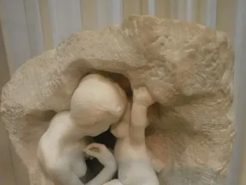 Young Mother in the Grotto, a white marble sculpture of a woman and child nestled inside a rough cave-like form.