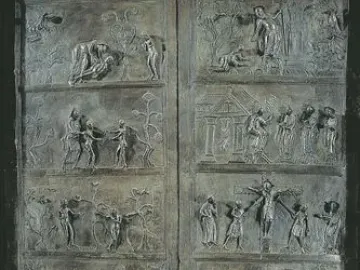 Bernward Doors with tall bronze relief panels showing multiple narrative scenes and lion-head knockers.