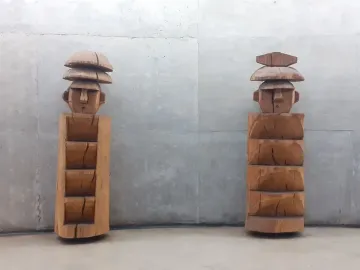 Chemamull wooden figures standing against a gray wall.
