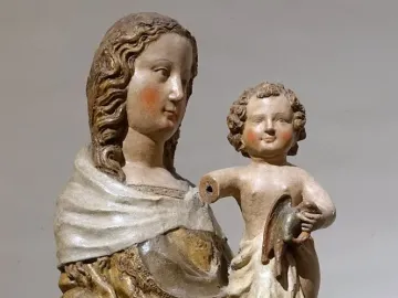 Friesentor Madonna, a polychrome sculpture of a woman holding a child with rosy cheeks and flowing hair.