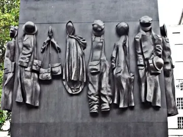 The Women of World War II monument with eleven relief figures and gold lettering.