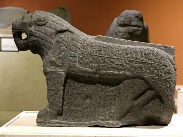 Maraş lion stone sculpture with an open mouth and carved inscriptions on its sides and legs.
