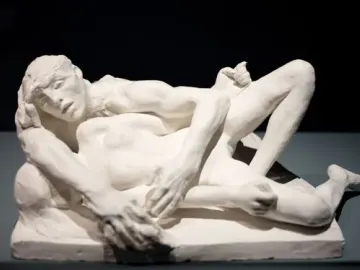 Auguste Rodin\'s Avarice and Lust showing two nude figures in a tight embrace on a base.