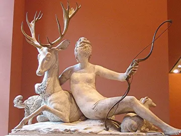 The Fountain of Diana, a marble sculpture of a nude woman with a bow embracing a stag, with two dogs on the basin below.