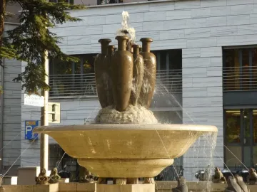 Fountain of the Frogs with a tiered stone basin and dark jugs on the top tier.