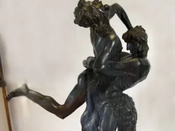 Bronze sculpture of Hercules and Antaeus showing one figure lifting the other high into the air.