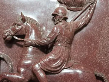 Close-up of a relief on the Sarcophagus of Helena showing a helmeted warrior on horseback raising a spear.