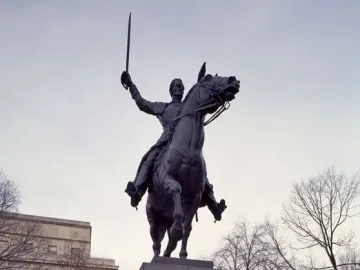 Simón Bolívar equestrian statue of a man in military uniform raising a sword while mounted on a rearing horse.