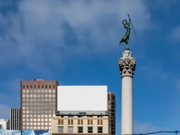 The Dewey Monument rises above Union Square, topped by a bronze figure holding a staff and wreath.