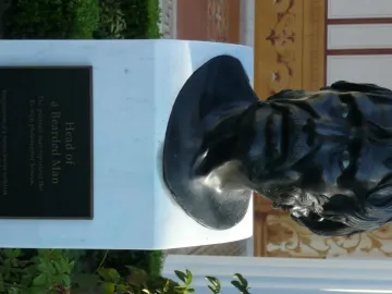 Pseudo-Seneca bronze bust of a bearded man on a white marble pedestal with an informational plaque.
