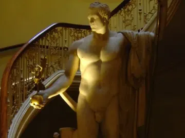 Napoleon as Mars the Peacemaker marble statue of a nude male figure holding a staff and orb beside a staircase