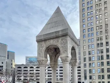 Bagley Memorial Fountain with a pointed roof and carved stone arches in an urban plaza.