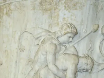 White marble relief on the Borghese Vase showing a draped woman and a nude man pulling at flowing fabric.