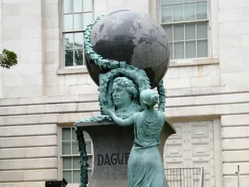 Daguerre Memorial granite monument with a bronze bust framed by a wreath, a draped female figure, and a globe on top