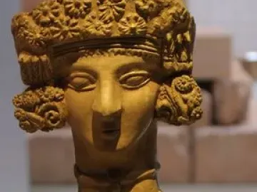 Lady of Ibiza clay figurine with elaborate headdress, necklaces, and decorated dress