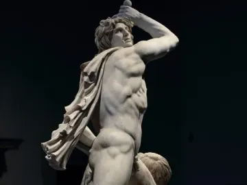Ludovisi Gaul sculpture with a muscular warrior raising a sword over his head beside a fallen figure.
