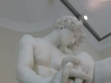 The Exiled, a white marble sculpture of a seated male figure with bowed head and clasped hands.